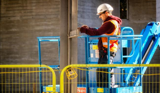 Electrical worker installing cables.