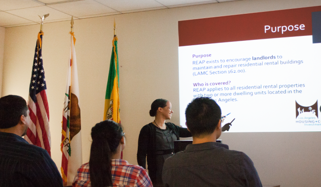 A female presenting on the purpose of REAP to a group of individuals