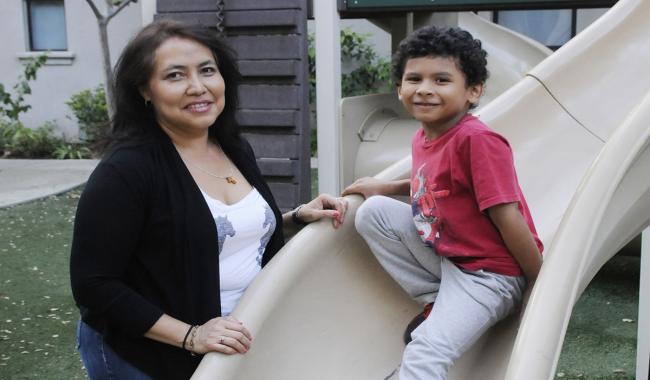 lady and boy standing by a slide